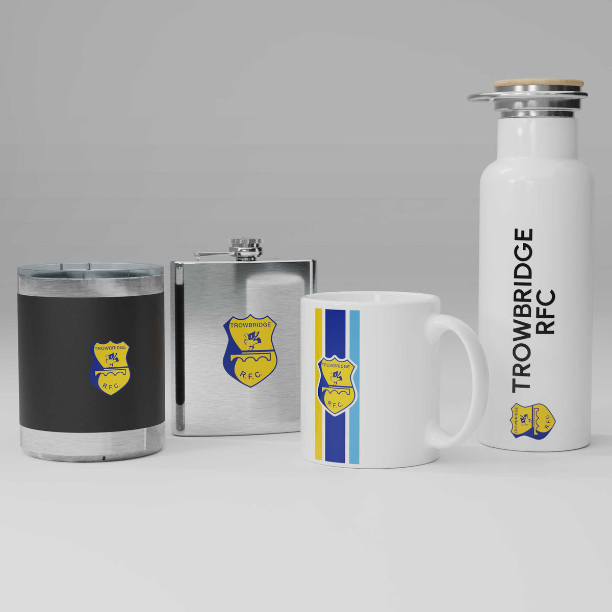 Collection of Trowbridge RFC branded items including a mug, flask, and water bottle on a gray background.